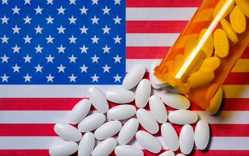 Pills being spilled over an American flag.