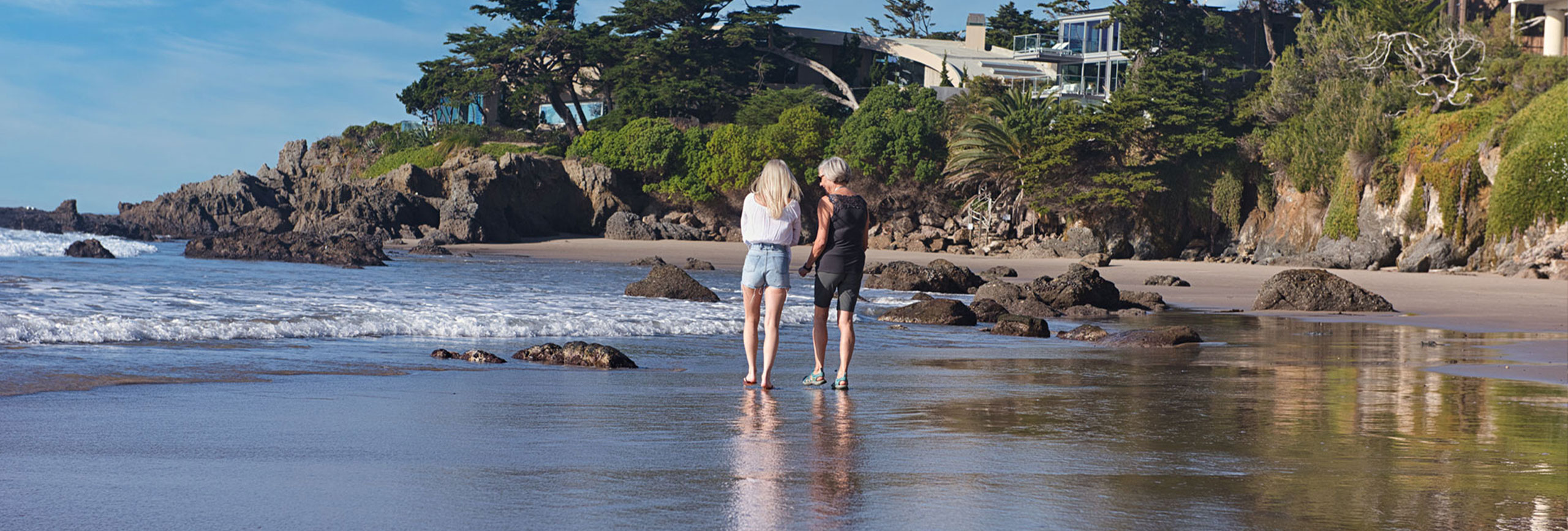 Rehab client and therapist walking the beach together in Malibu, California.