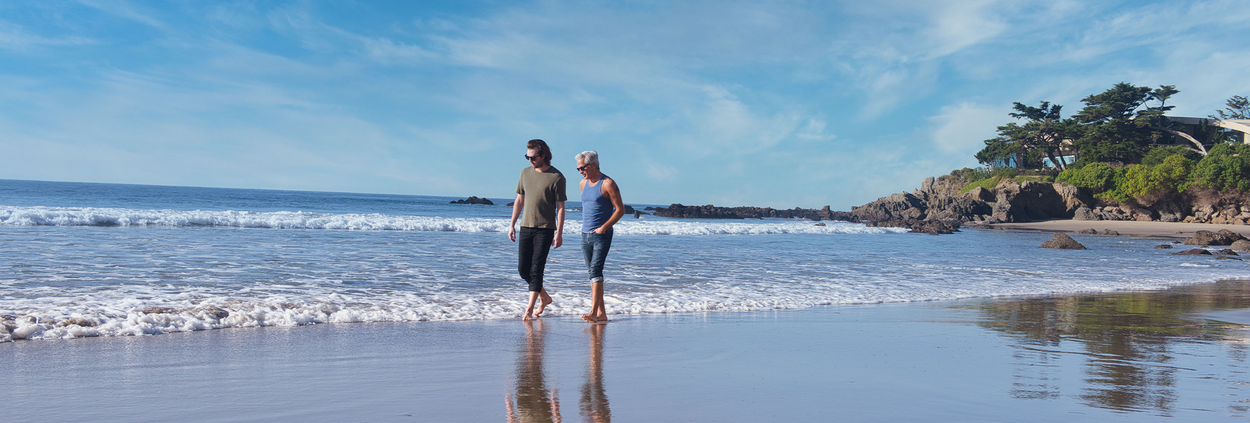 Two luxury rehab clients walking along the beach.